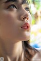 A close up of a woman's face with her eyes closed.